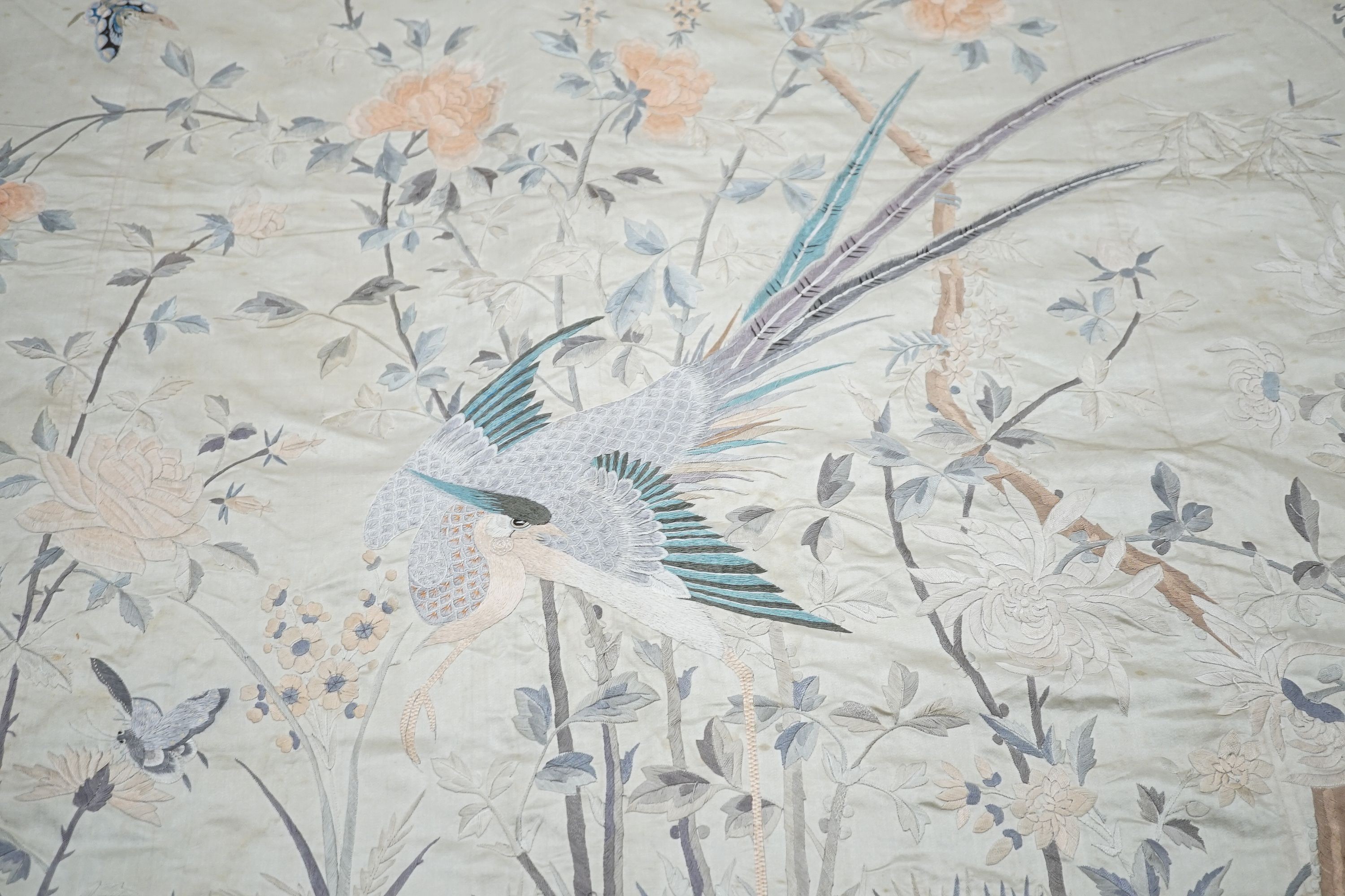 A grey silk satin Chinese embroidered panel edged with deep fringing covered with pale grey pink and beige embroidery and birds and flowers, 78 x 96cm excluding fringing